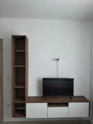 a flat screen tv sitting on top of a entertainment center at Talic Apartmani in Sutomore