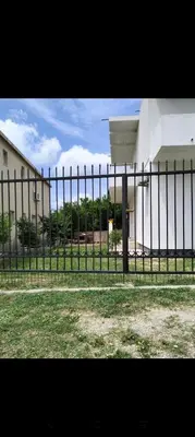a black fence in front of a building at Talic Apartmani in Sutomore