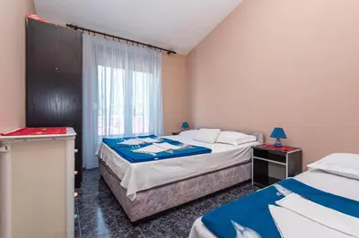 a hotel room with two beds and a window at Apartmani Dresic in Sutomore