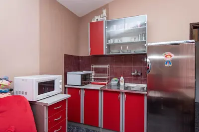 a kitchen with red cabinets and a stainless steel refrigerator at Apartmani Dresic in Sutomore