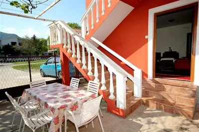 a table and chairs on the porch of a house at Apartmani Dresic in Sutomore