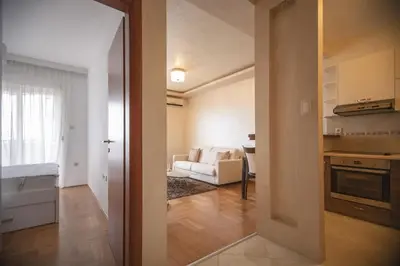 a kitchen and a living room with a white couch at Vista Suite in Budva