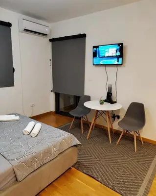 a bedroom with a bed and a table and a tv at Apartment Stefan in Budva