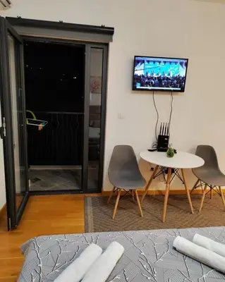 a living room with a table and chairs and a tv at Apartment Stefan in Budva