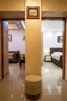 a bedroom with a bed and a stool in a room at Apartmani Milica Mica Kotor Dobrota in Kotor
