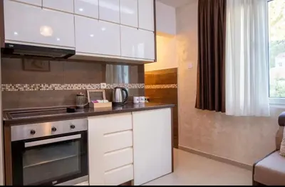 a kitchen with white cabinets and a stove at Apartmani Milica Mica Kotor Dobrota in Kotor