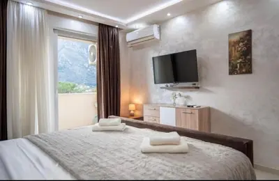 a bedroom with a bed with two towels on it at Apartmani Milica Mica Kotor Dobrota in Kotor