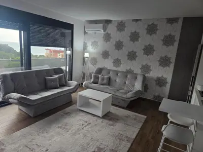 a living room with two couches and a table at Apartman Gold.HD in Dobra Voda