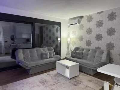 a living room with two couches and a table at Apartman Gold.HD in Dobra Voda