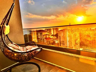 a hammock on a balcony with a view of a city at Apartman Gold.HD in Dobra Voda