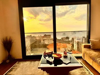 a living room with a large window with a view at Apartman Gold.HD in Dobra Voda