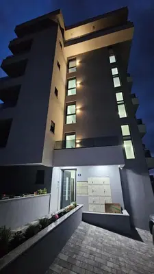 a large building with a walkway in front of it at Apartman Gold.HD in Dobra Voda