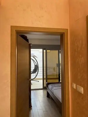 a door leading to a room with a bed and a doorway at Sunrise Apartments 1 in Dobra Voda