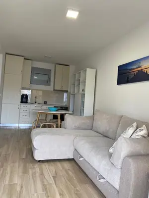 a living room with a couch and a kitchen at Sunrise Apartments 1 in Dobra Voda