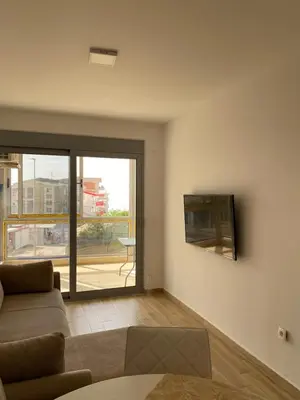 a living room with a couch and a tv on the wall at Sunrise Apartments 1 in Dobra Voda