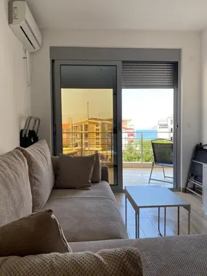 a living room with a couch and a table at Sunrise Apartments 1 in Dobra Voda