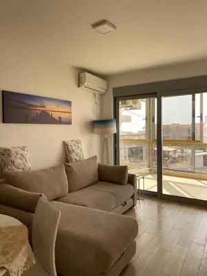 a living room with a couch and a large window at Sunrise Apartments 1 in Dobra Voda