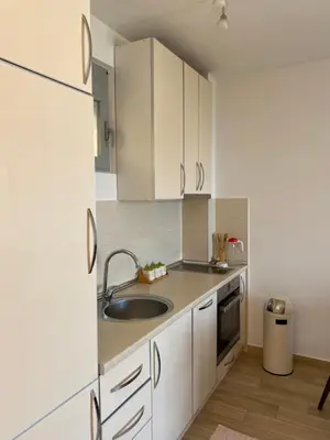 a kitchen with white cabinets and a sink at Sunrise Apartments 1 in Dobra Voda