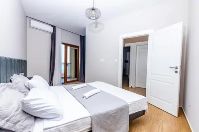 a bedroom with two beds with white sheets at Apartman DELUXE in Budva