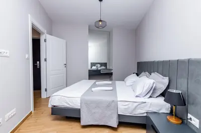 a bedroom with a large bed with white sheets at Apartman DELUXE in Budva