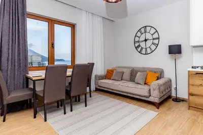 a living room with a table and a couch at Apartman DELUXE in Budva
