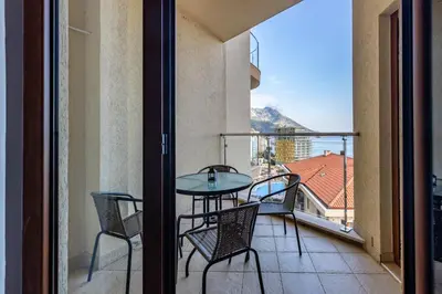 a balcony with a table and chairs and a view at Apartman DELUXE in Budva