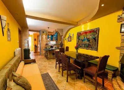 a yellow living room with a table and chairs at Gala’s Miracle Garden in Budva