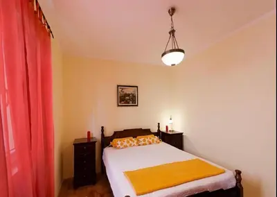 a bedroom with a bed and a red curtain at Gala’s Miracle Garden in Budva