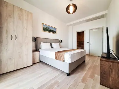 a bedroom with a bed and a flat screen tv at Casa Oliva Villa A with heating pool in Budva
