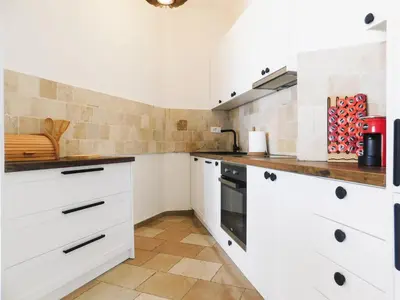 a kitchen with white cabinets and a stove at Casa Oliva Villa A with heating pool in Budva