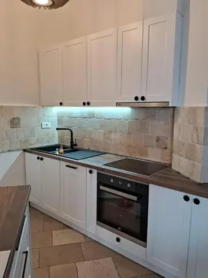a kitchen with white cabinets and a sink at Casa Oliva Villa A with heating pool in Budva