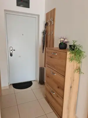a wooden dresser with flowers on it next to a door at The Sun & Sea Apartment in Becici
