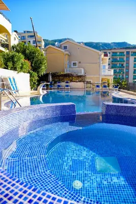 a large swimming pool with blue tiles in a building at The Sun & Sea Apartment in Becici