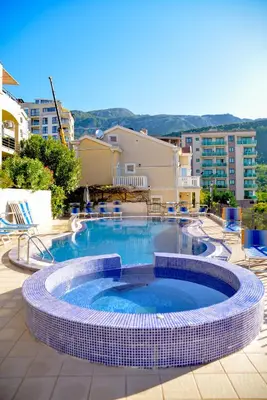 a swimming pool in a resort with chairs and buildings at The Sun & Sea Apartment in Becici