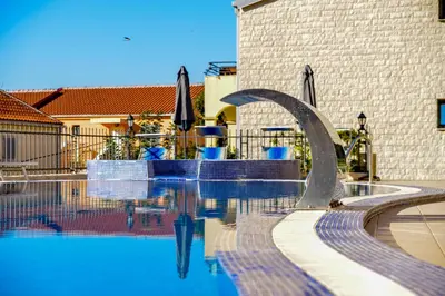 a swimming pool with umbrellas next to a building at The Sun & Sea Apartment in Becici