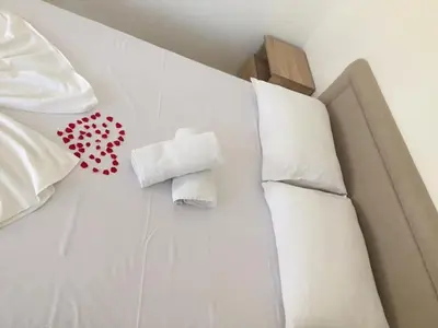 a bed with white pillows and a towel on it at Blue Dream in Ulcinj