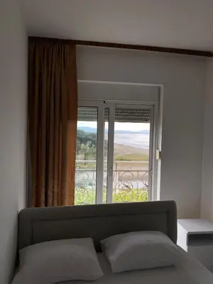 a bedroom with a bed and a large window at Blue Dream in Ulcinj