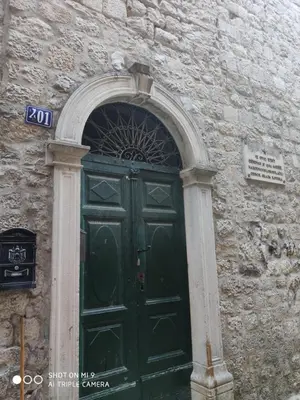 a green door in a stone building with an arch at KOTOR OLD TOWN 2 bedroom apartment in Kotor