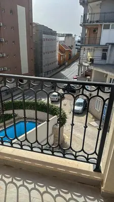 a balcony with a fence and a swimming pool at Apartman ANNA ATINA Budva in Budva