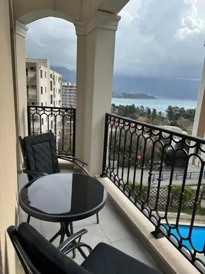 a balcony with a table and chairs and a view of the ocean at Apartman ANNA ATINA Budva in Budva