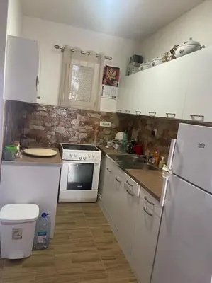 a kitchen with white cabinets and a stove and refrigerator at Kadmi in Njeguši
