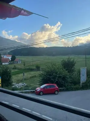a red car parked on the side of a road at Kadmi in Njeguši