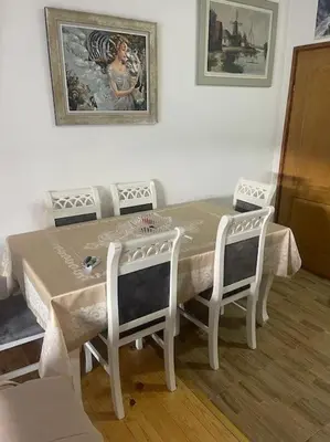 a dining room table with four chairs and a painting on the wall at Kadmi in Njeguši