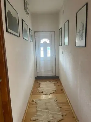a hallway with wooden floors and a white door at Kadmi in Njeguši