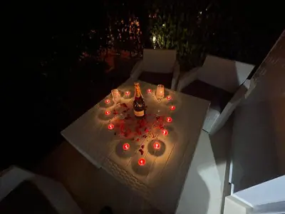 a white table with candles and wine bottles on it at Apartments Pericic LUX in Sutomore