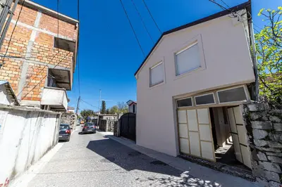 a white building with a door on a street at Old Street in Podgorica