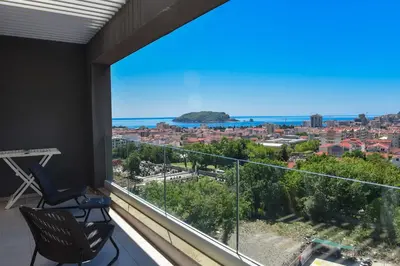 a balcony with a view of the city and the ocean at New Chill and Go Apartments in Budva