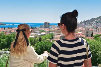 two women standing on a hill looking at a city at New Chill and Go Apartments in Budva