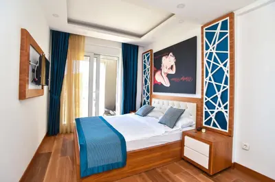 a bedroom with a bed with blue and white sheets at New Chill and Go Apartments in Budva