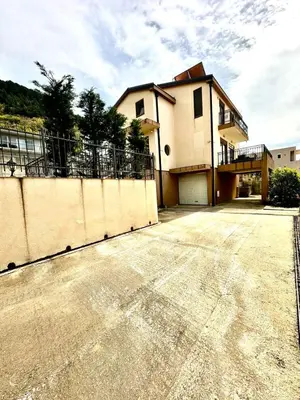 a house with a fence in front of a driveway at Villa Sun in Kotor